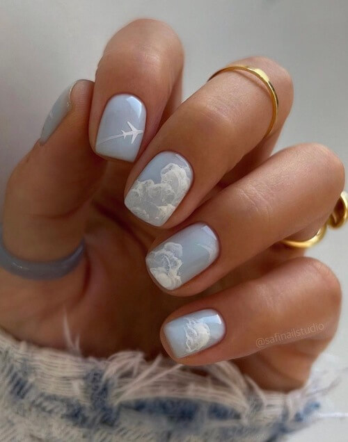 sky nail designs with an airplane and clouds